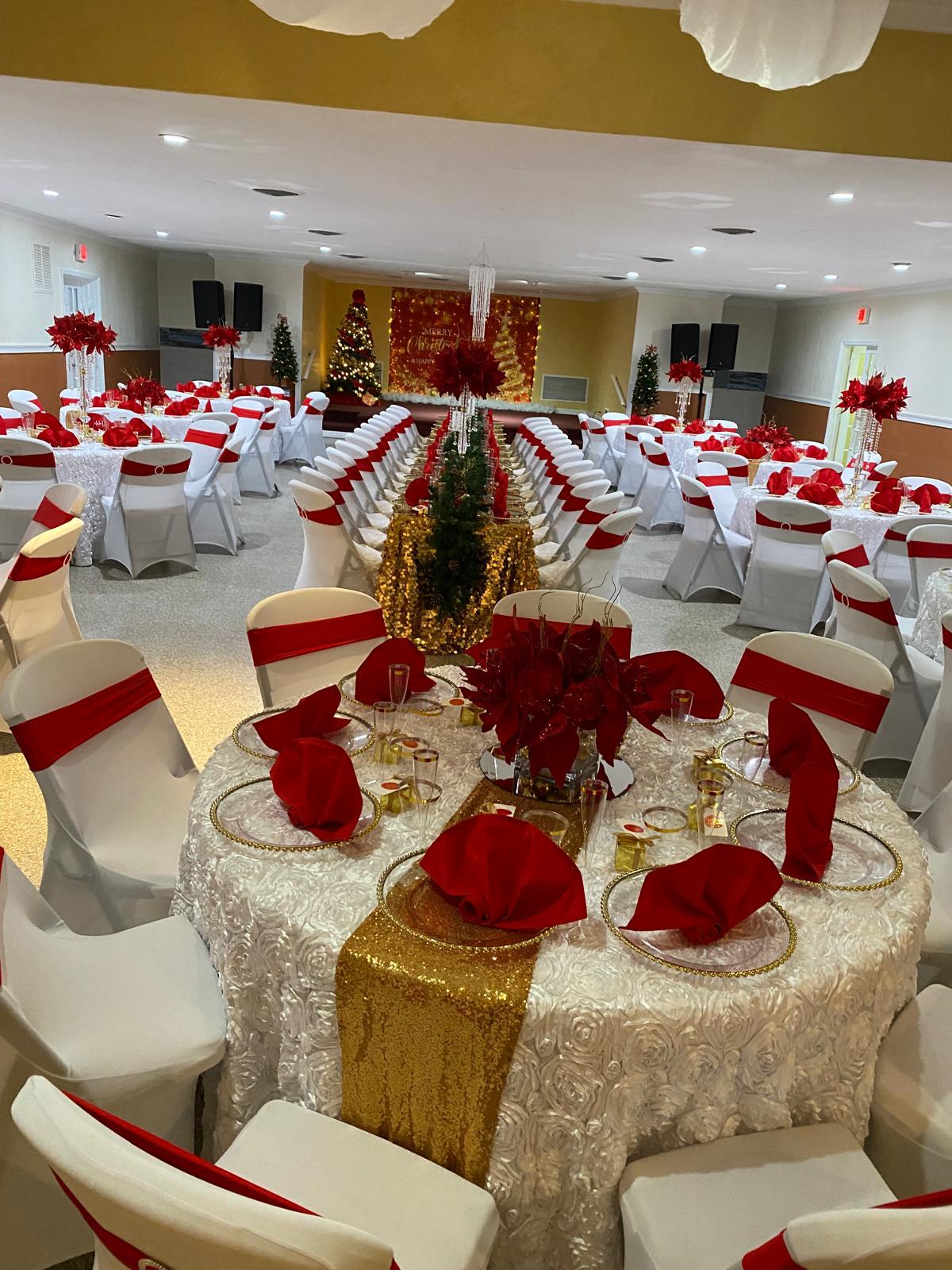 Banquet hall decorated for a celebration with draped backdrop.