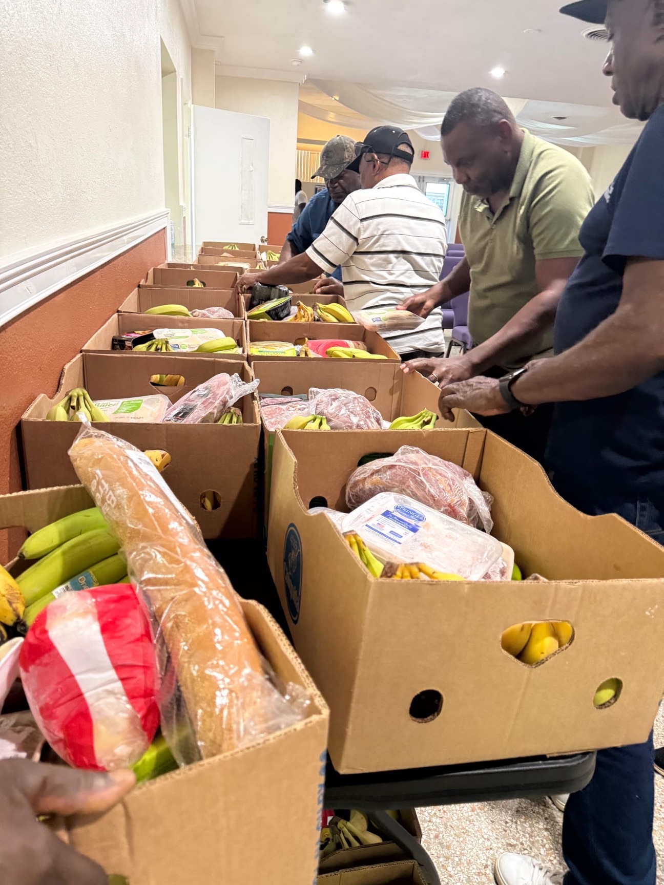 Volunteers organizing packaged food for distribution.