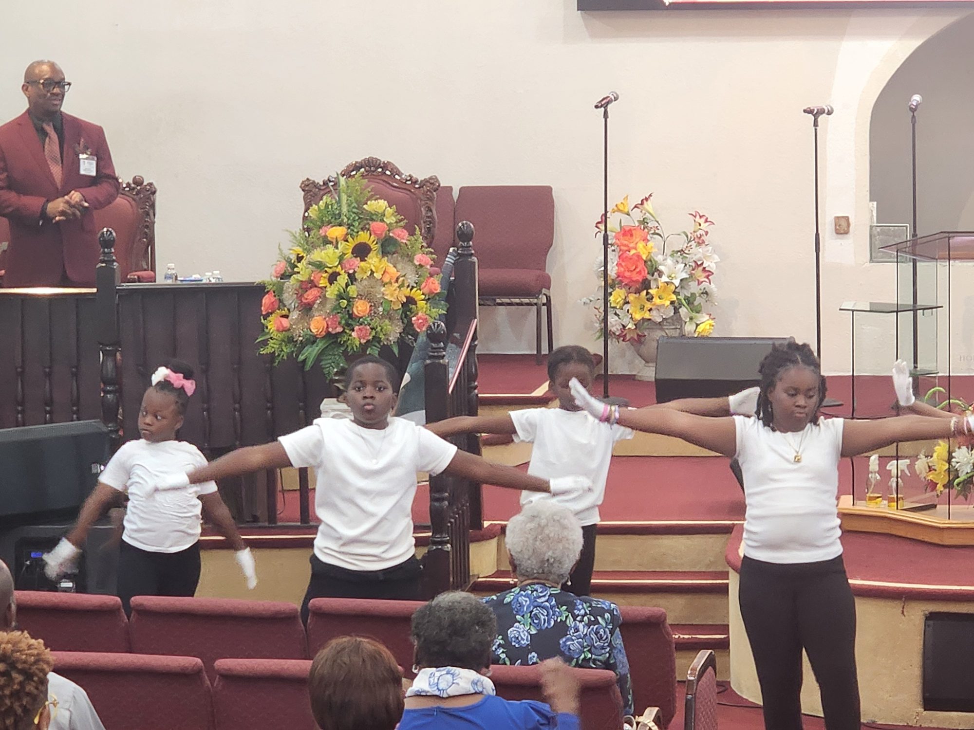 Children in white shirts performing a choreographed presentation at Ingathering.