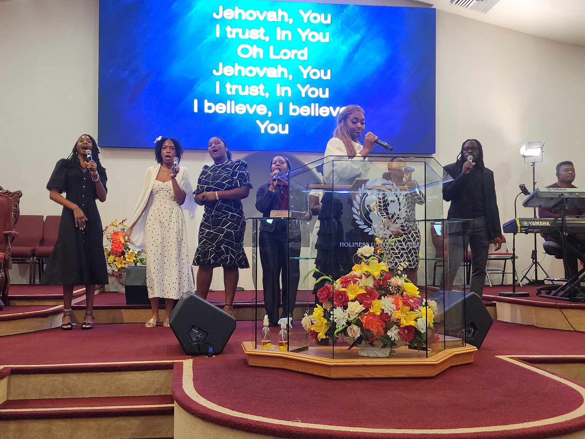 Women of the praise team singing during Ingathering worship.
