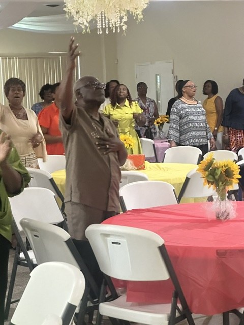 Guests standing in prayer during the Know Your Neighbor Prayer Breakfast.